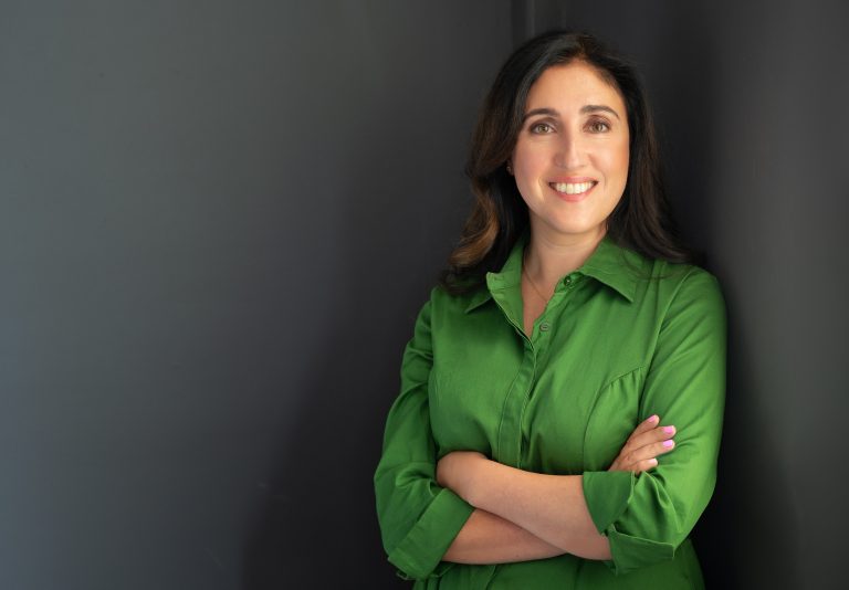 portrait photo of Renee Mcallister, founder of Xperia, wearing a green dress